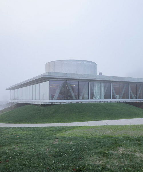 horizontal disk anchors office building by MVA on three greened mounds near zagreb